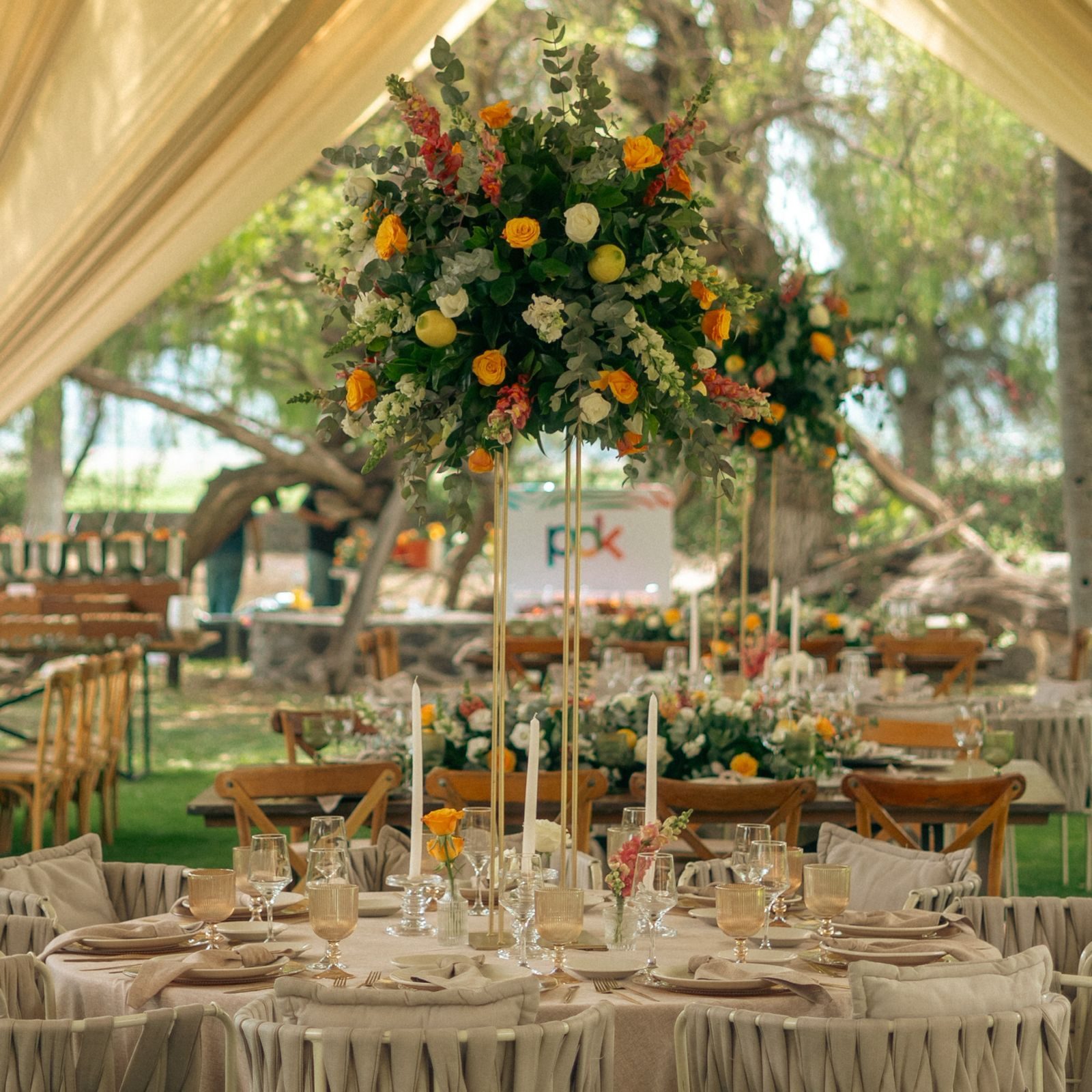 Banquete con centros de mesa altos de flores naranjas en Hacienda Dolores, Querétaro