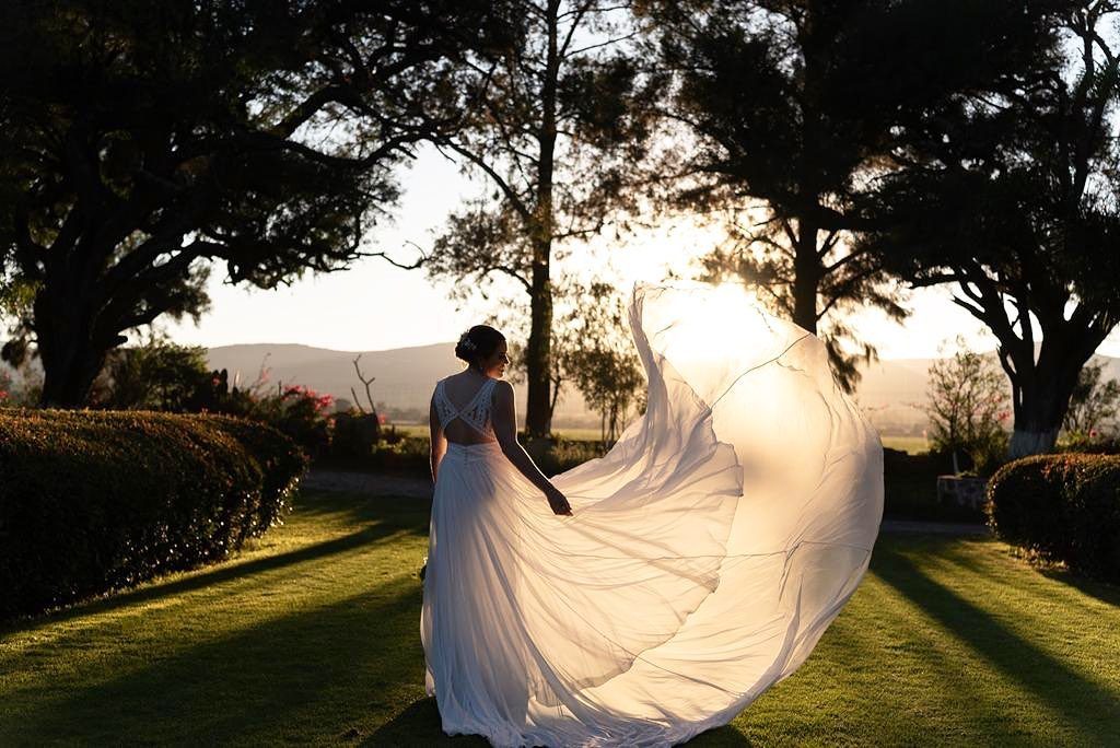 Novia de espaldas al atardecer en los jardines de Hacienda Dolores, bodas en Querétaro