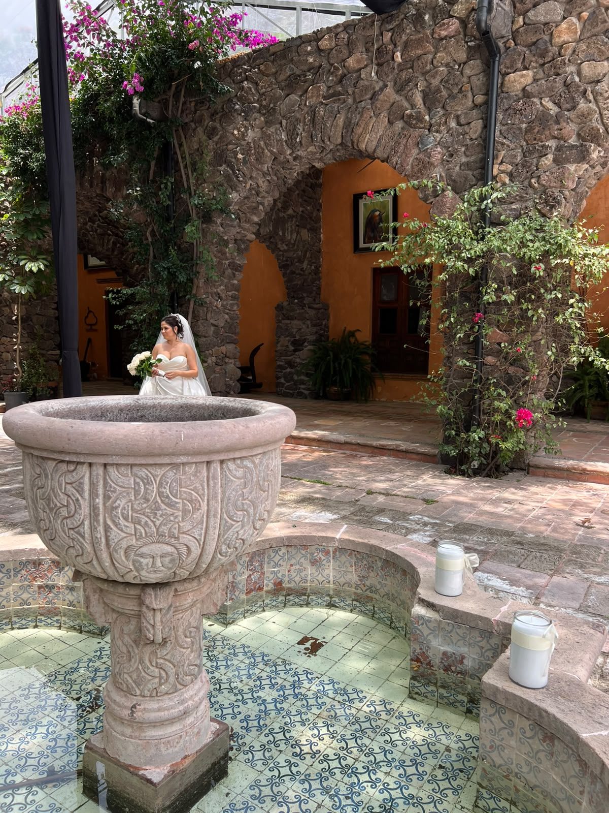 Fuente de cantera en patio con buganvilias de Hacienda Dolores, Querétaro