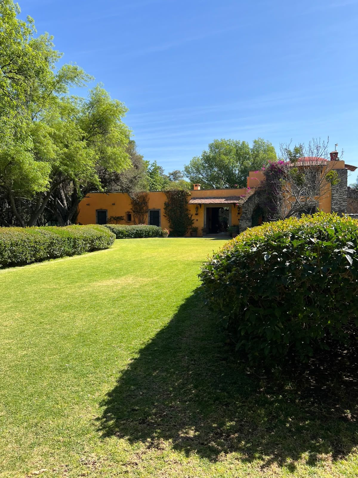 Jardín con setos y vista a la casona de Hacienda Dolores, Querétaro