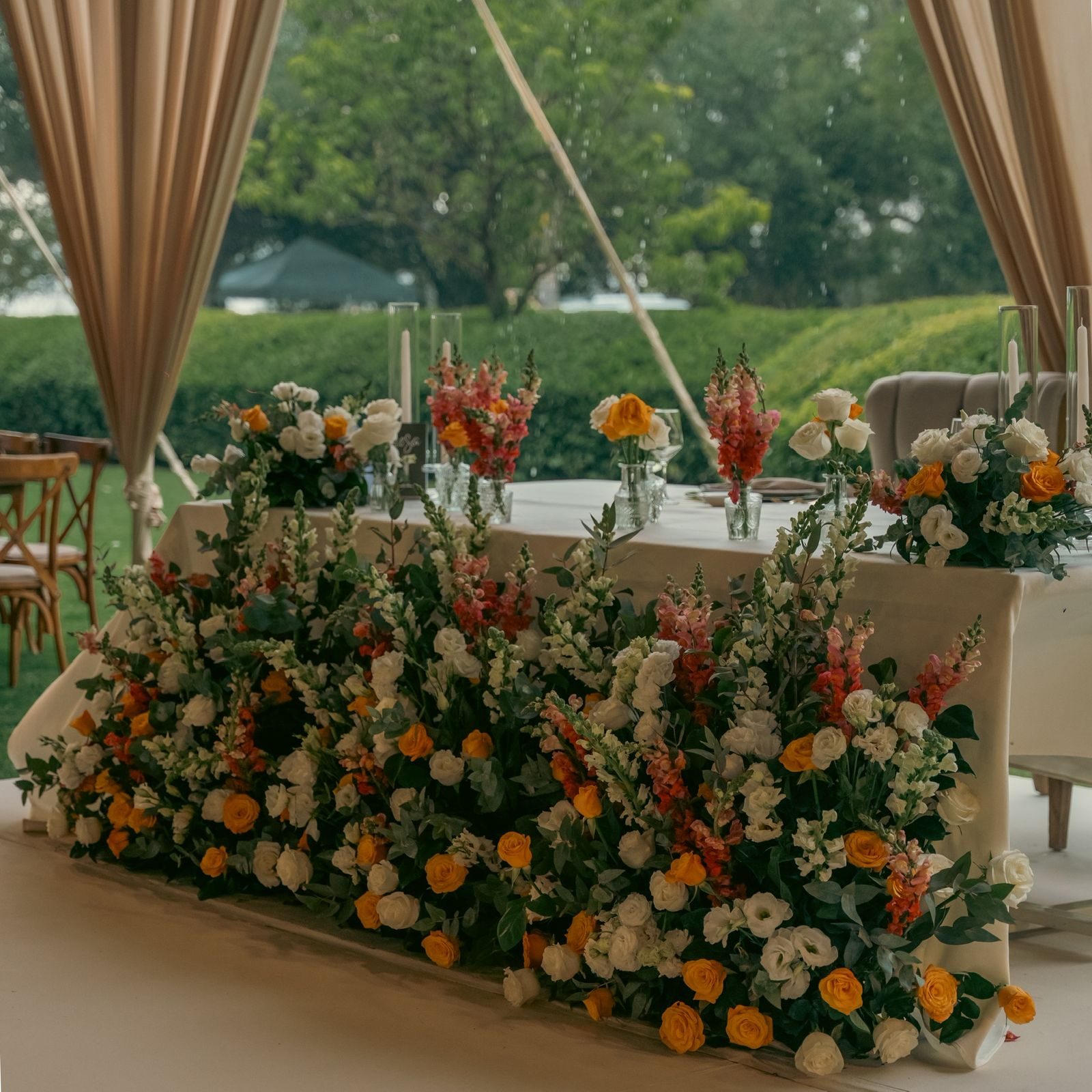 Mesa principal de novios con flores naranjas en Hacienda Dolores, Querétaro